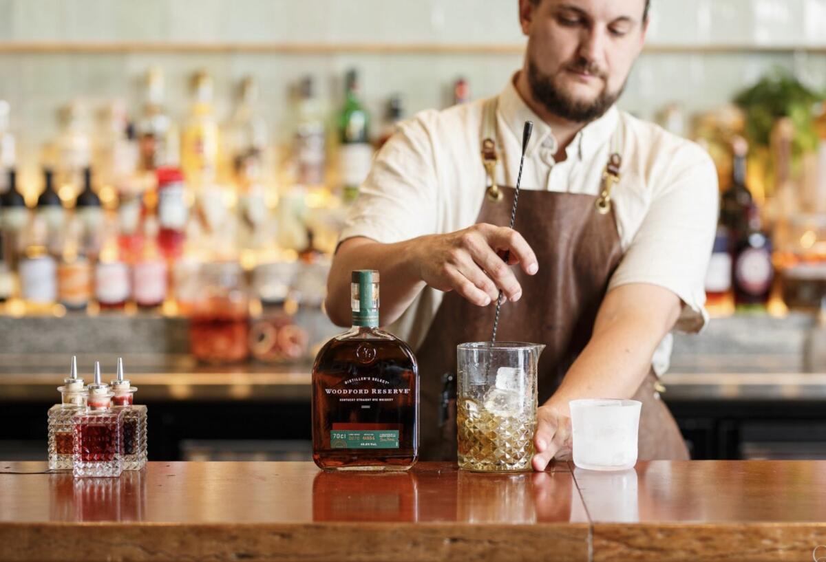 Tom mixing a Woodford Reserve cocktail behind The Exhibitionist Bar (image supplied)