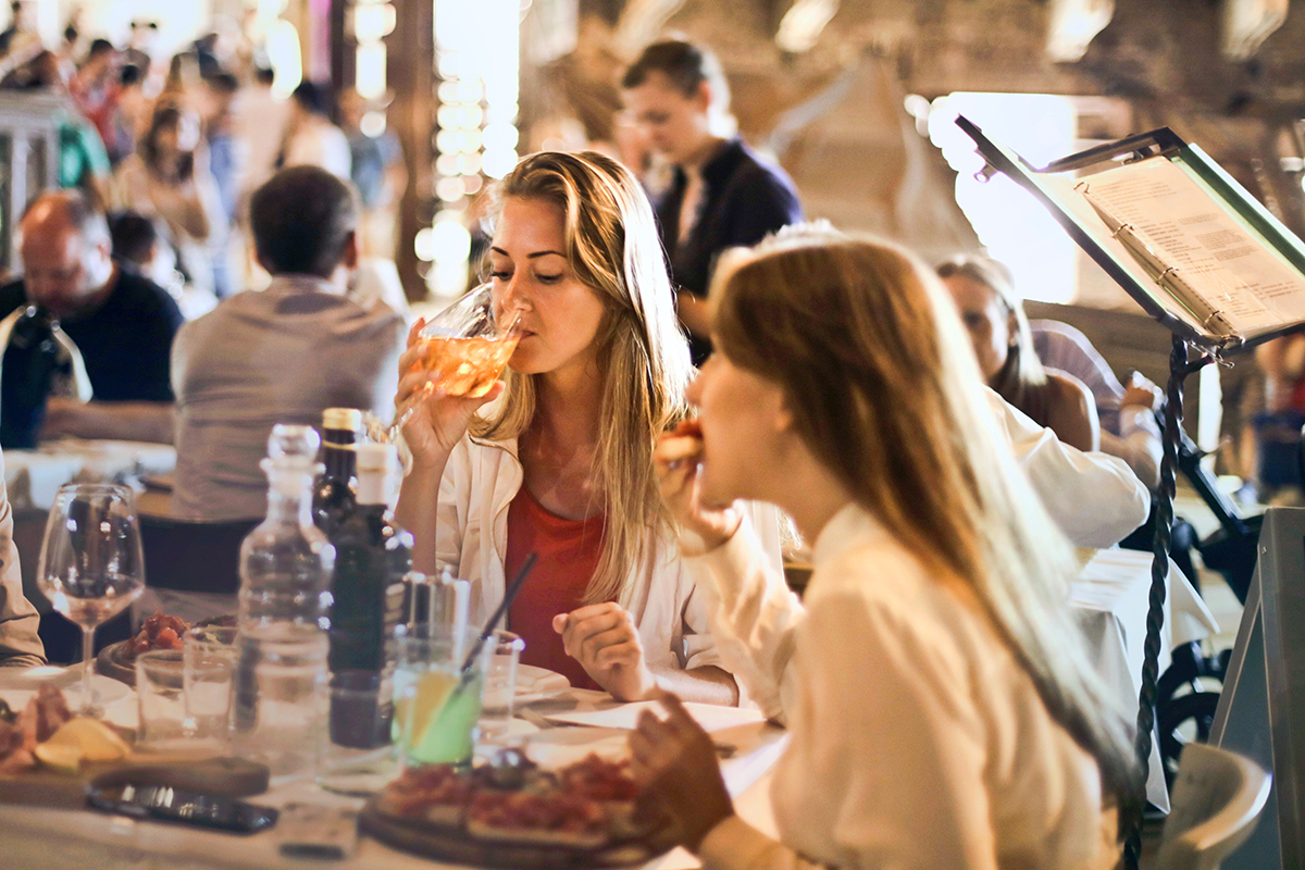 Friends eating out (image via pexels)