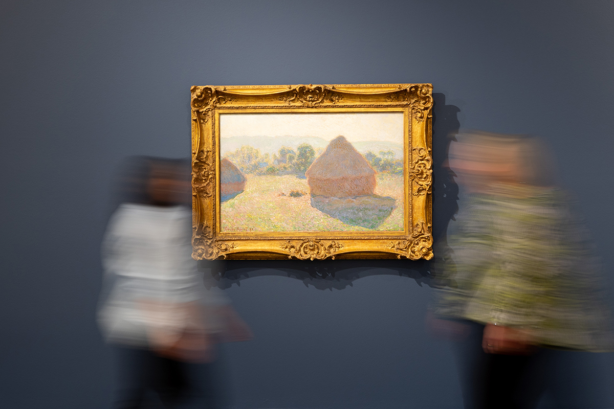Tweed Regional Gallery Curator - Exhibitions Tina Wilson hanging Claude Monet's masterpiece Meules, milieu du jour [Haystacks, midday], 1890 (image by Luke Marsden)